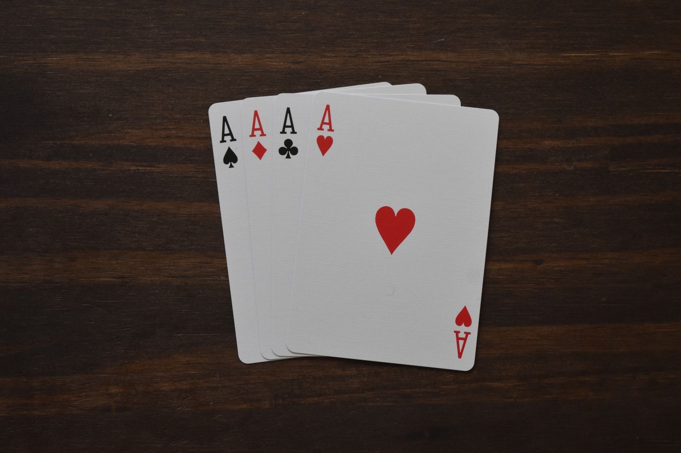 Four aces on a wooden table
