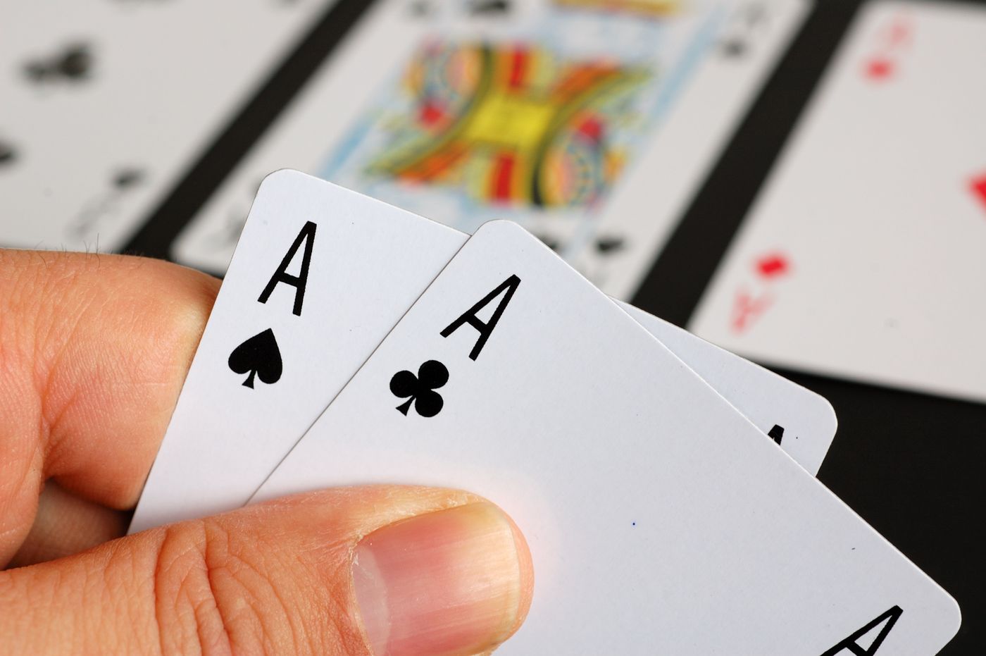 A hand holding two aces
